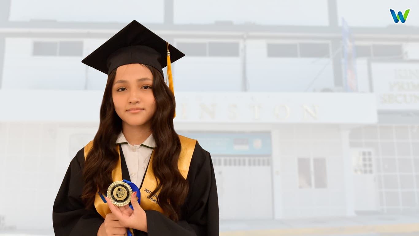 Alumna con medalla frente al campus Winston